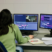 Female editor working with three screens