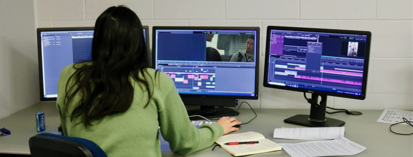 Female editor working with three screens