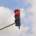 Red traffic light against clouds in the sky