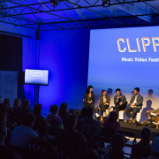 A panel of speakers in front of a festival audience.