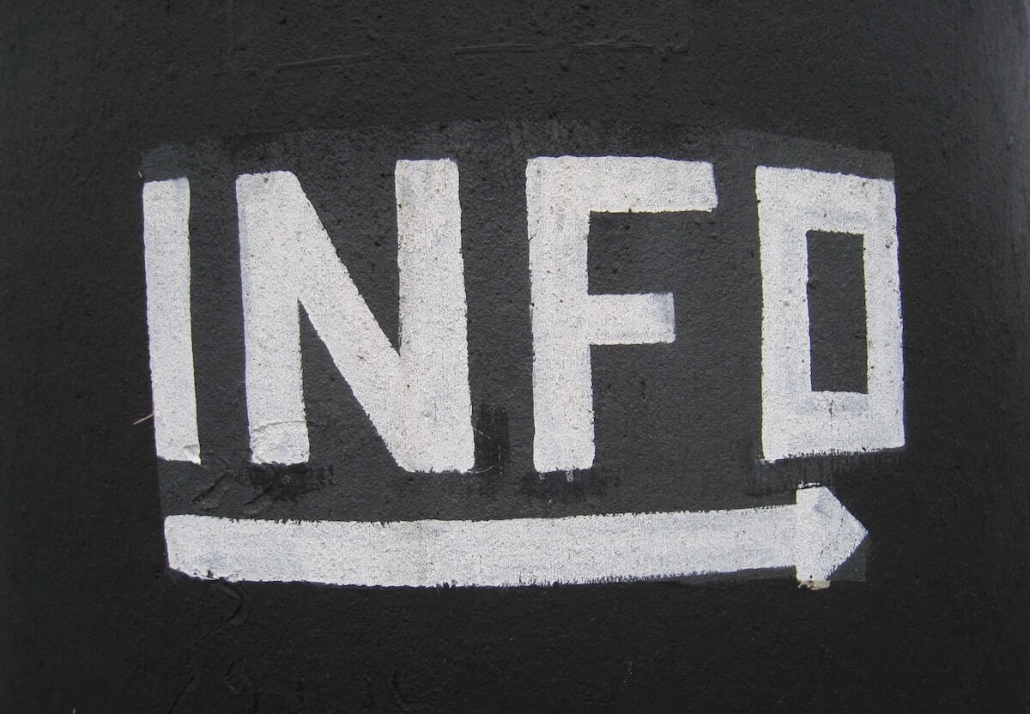 Black sign with INFO in white paint.