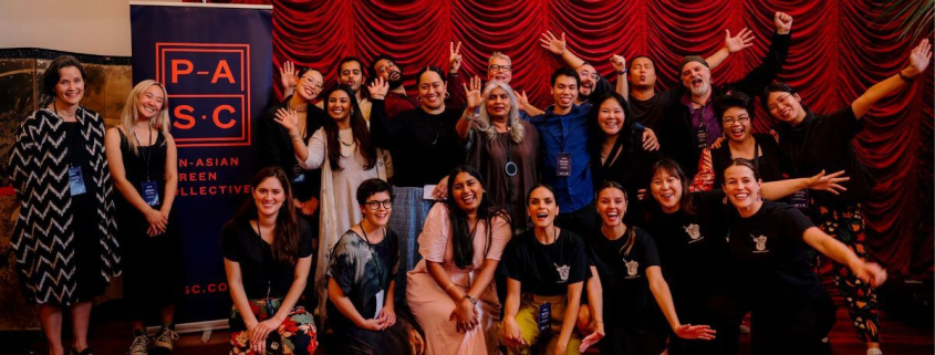 Episode One participants, Shuchi Kothari, and Dale Corlett stand in front of a red curtain and PASC banner